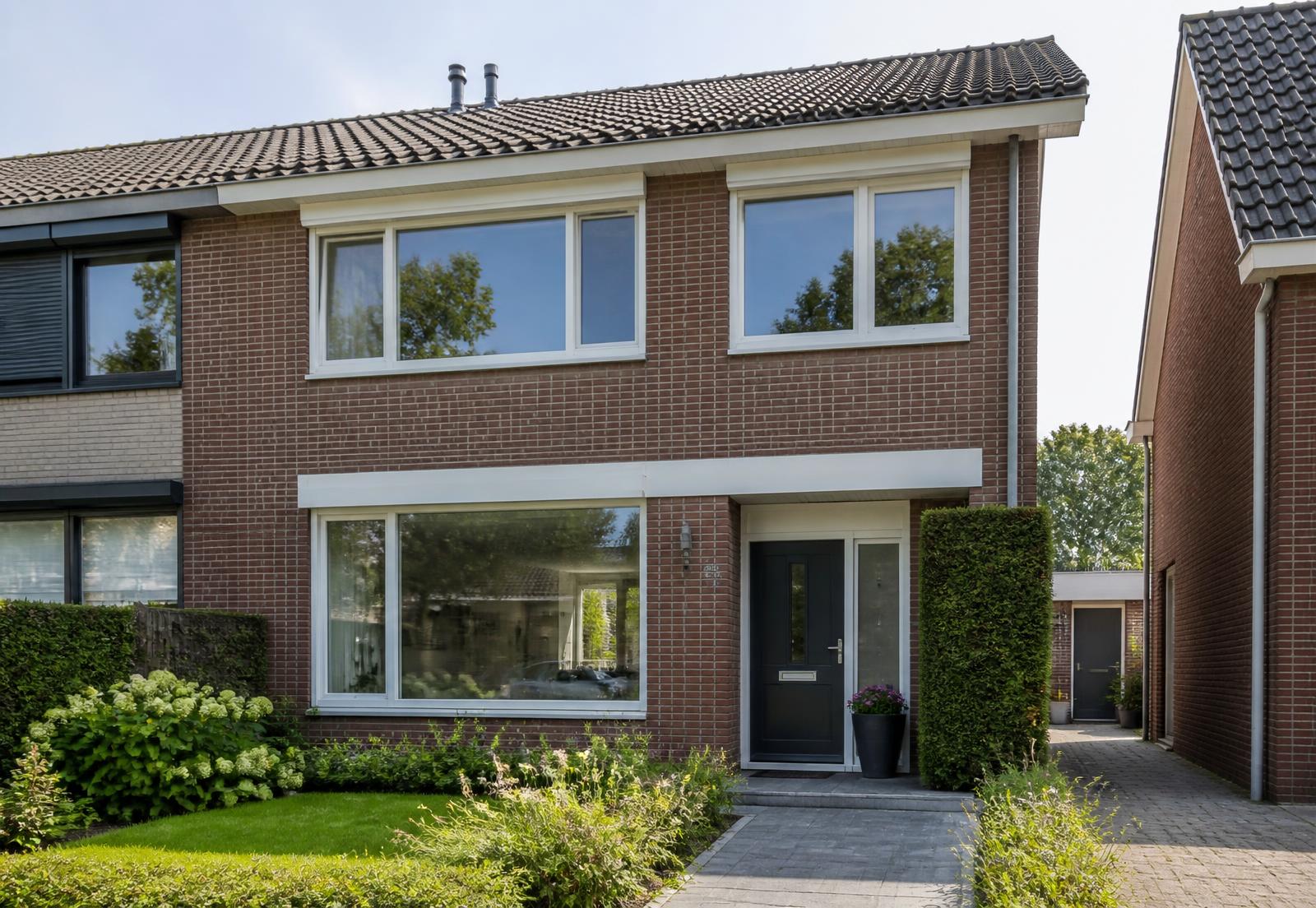 Nederlandse woning met nieuwe witte kunststof kozijnen en een antraciet voordeur